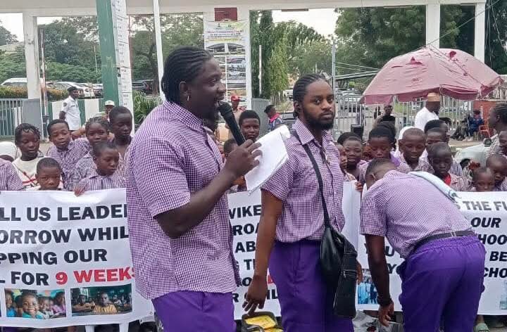 Social media activist #VeryDarkMan takes the fight to Minister #Wike’s doorstep, teaching schoolchildren outside the FCT office in protest of the ongoing primary school teachers’ strike.