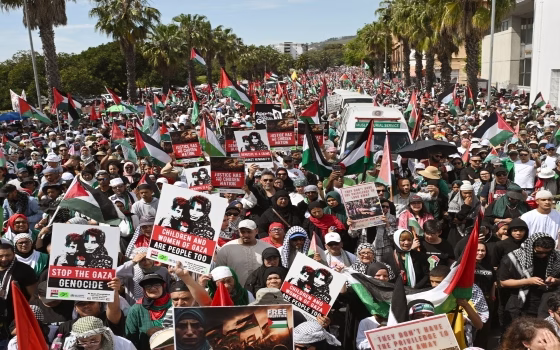 Protesters hold placards and Palestinian flags as they march through the city centre during a civil society and faith-based organizations’ mass rally for Gaza, in Cape Town on September 27, 2025. (Photo by RODGER BOSCH / AFP)