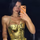 Dua Lipa using the orange iPhone 17 Pro.